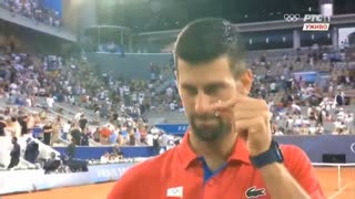 Novak Djokovic showing his Christian cross after his victory